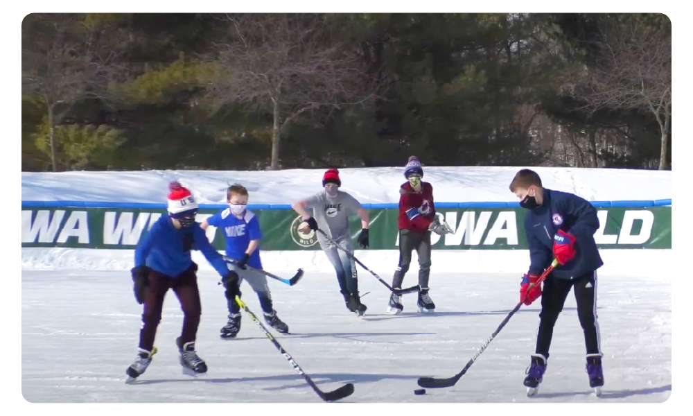 Children playing hockey on an outdoor ice rink